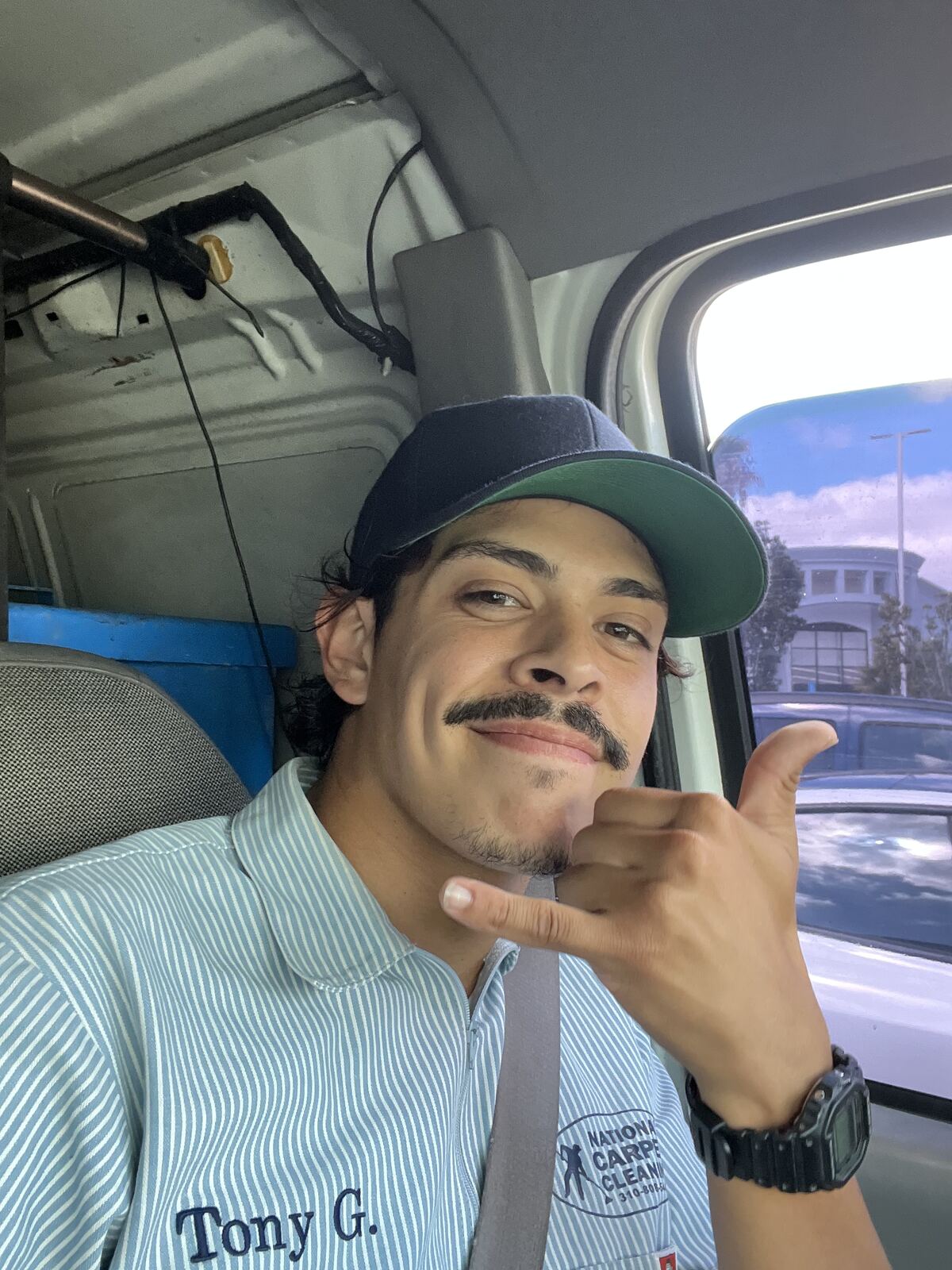 Tony in his National Carpet Cleaning work shirt inside the service van
