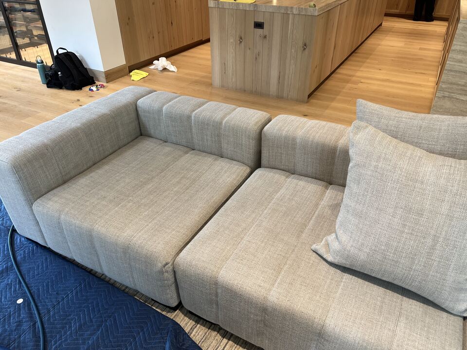 The same cream modular sofa left seat and arm after upholstery cleaning, with throw pillows restored