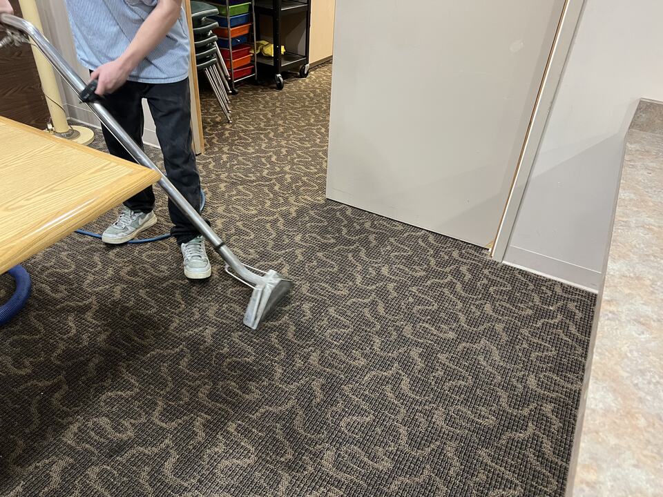 A carpet-cleaning wand in use on patterned commercial carpet
