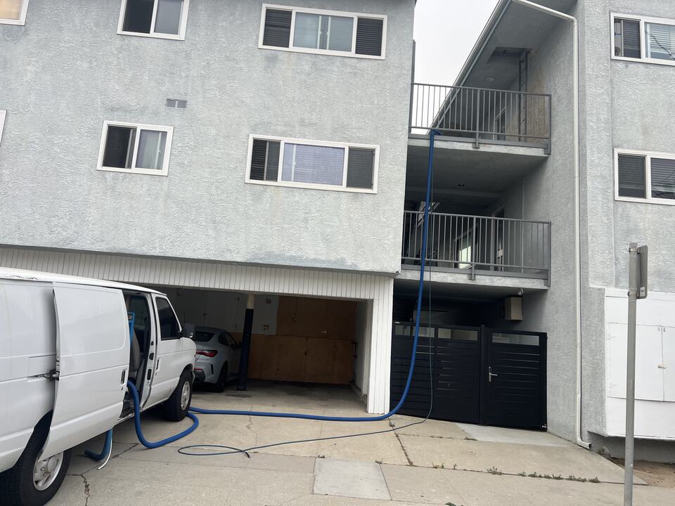 Cleaning hoses extending from a van to a multi-story building