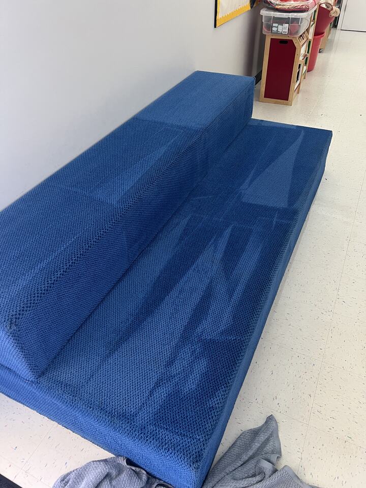 Blue upholstered bench with cleaning passes visible