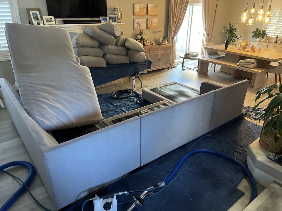 Sofa cushions and upholstery equipment during cleaning work